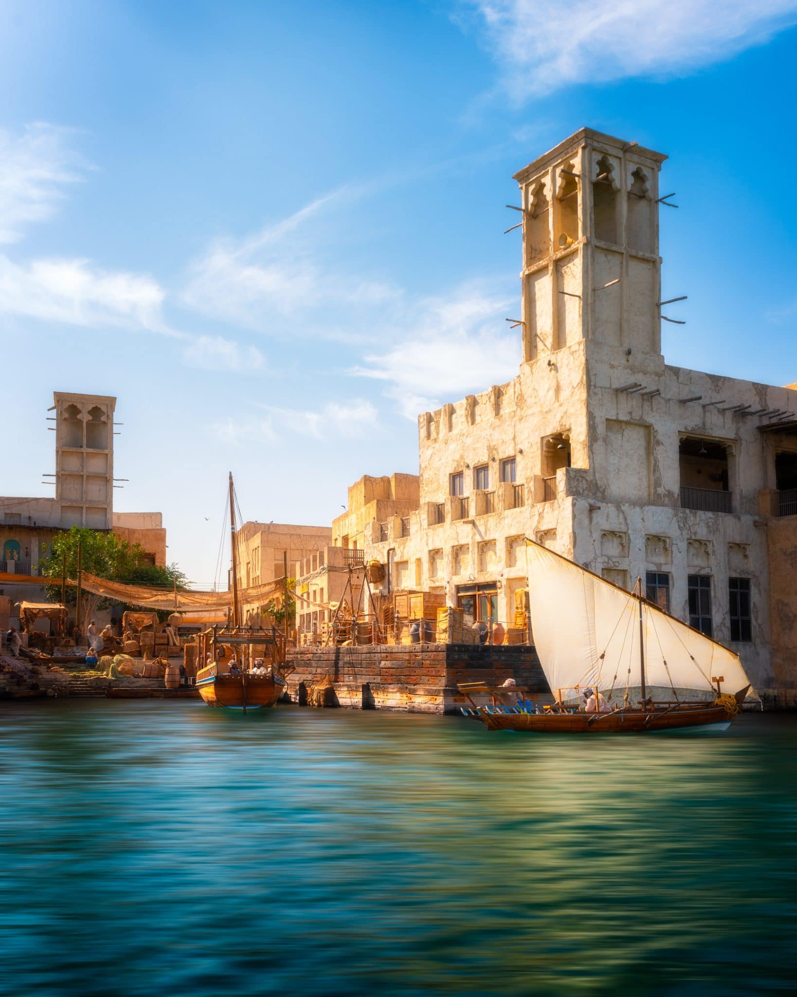Paisagem tradicional ao atravessar o Dubai Creek com edifícios históricos em fundo.