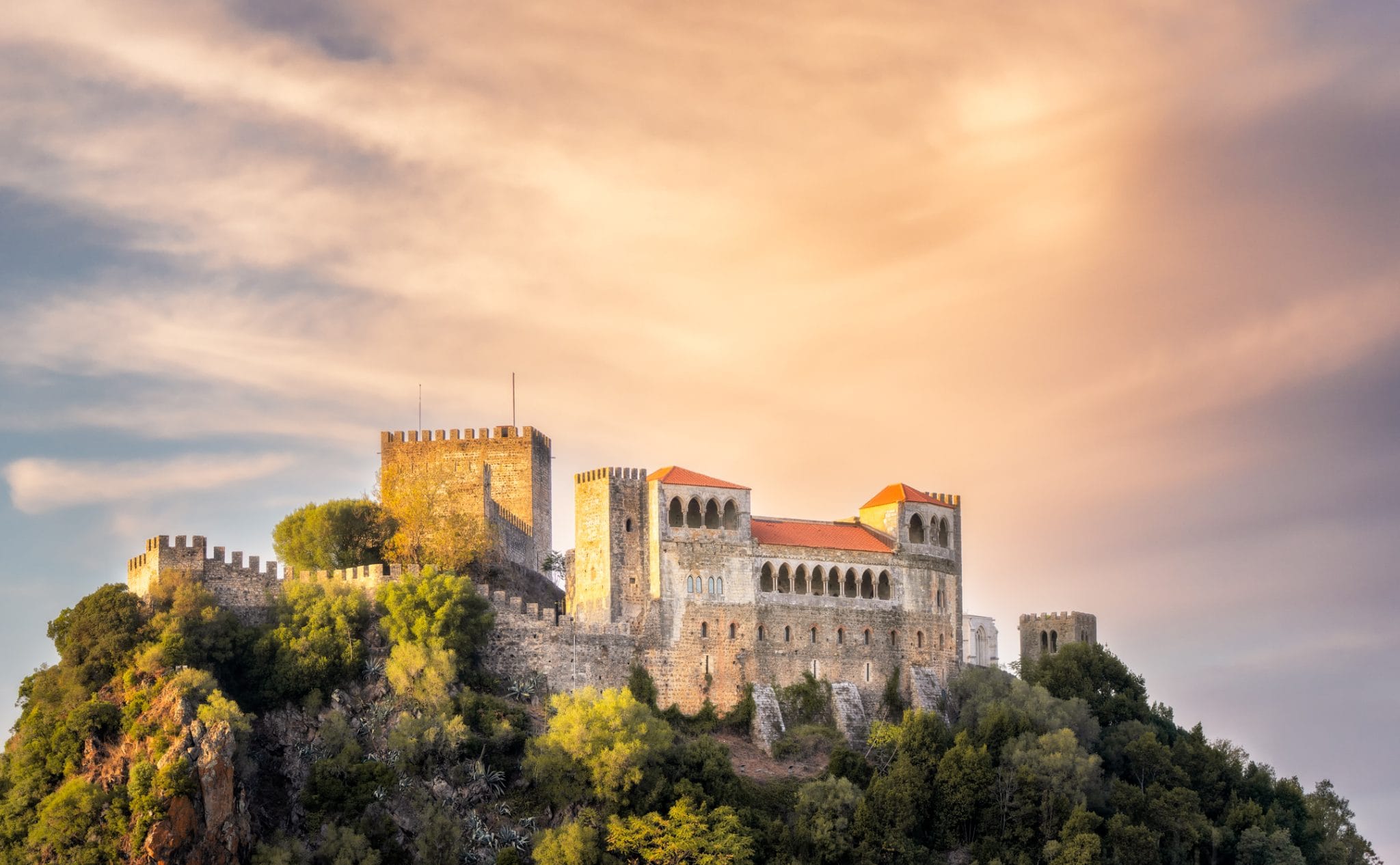 Το κάστρο της Λεϊρία λάμπει στο ζεστό φως του ηλιοβασιλέματος, με εντυπωσιακά σύννεφα να υψώνονται πάνω από το μεσαιωνικό φρούριο στην κεντρική Πορτογαλία
